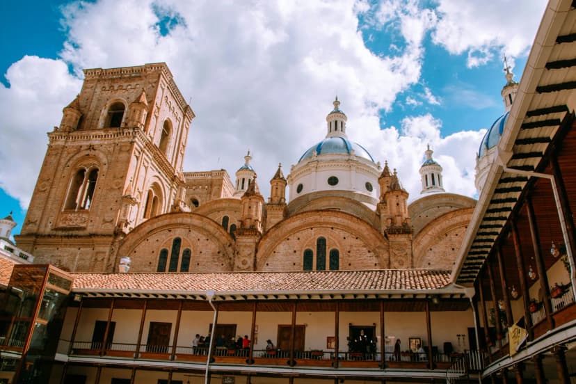Cuenca cathedral and colonial rooftops beneath bright blue sky