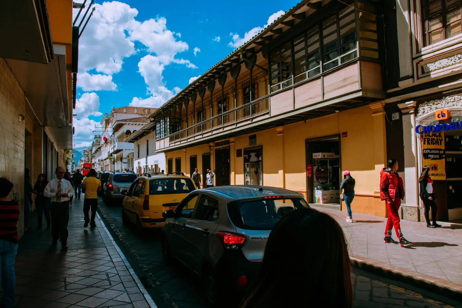 Everyday street life and yellow taxis in Cuenca's historic center